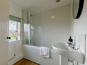 A bathroom with a glass-enclosed shower, a white sink, and a window with flowers. - 3 Bed in Pershore (oc-92975) (Eckington)