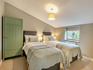 A bedroom with two beds, a green wardrobe, a window with a view, and a ceiling light. - 2 Bed in Barnstaple (oc-93023) (Chapelton)