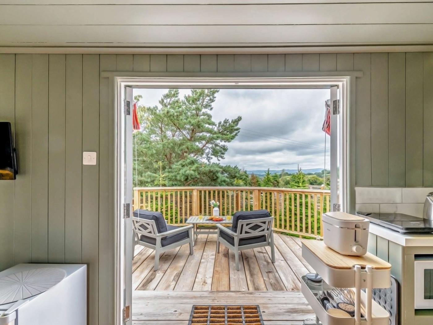A deck with outdoor seating and a kitchen area.