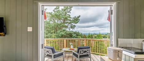 A deck with outdoor seating and a kitchen area.