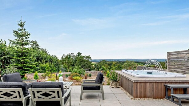 A patio with outdoor furniture, a hot tub, and a view of a forested landscape. - 1 Bed in Paignton (oc-93061) (Marldon)