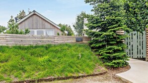 A rustic wooden building with a sloped roof, a wooden fence, and a well-maintained grassy area. - 1 Bed in Paignton (oc-93061) (Marldon)