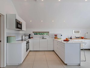 A modern kitchen with white cabinetry, a built-in oven, and a microwave. - 1 Bed in Paignton (oc-93061) (Marldon)