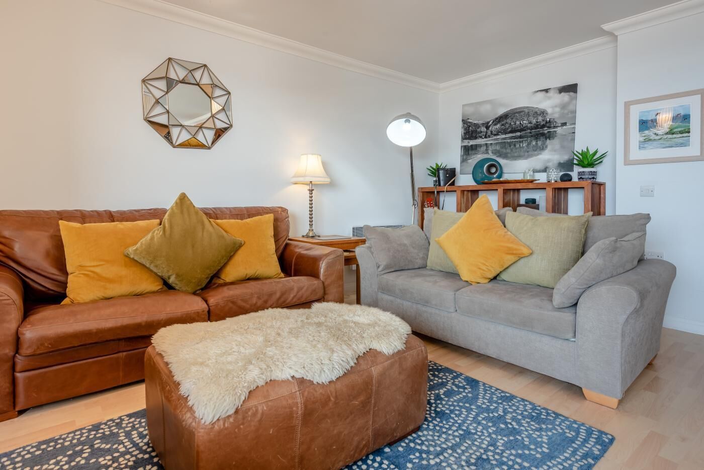 A living room with two sofas, a coffee table, a lamp, and a painting on the wall.