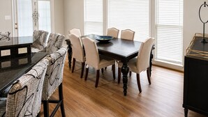 Uma sala de jantar com uma mesa de madeira escura, seis cadeiras e uma tigela decorativa.