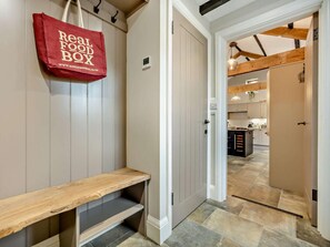 A hallway with a bench, a door, and a kitchen area visible through an open door. - 2 Bed in Cleator (oc-93196) (Ennerdale and Kinniside)