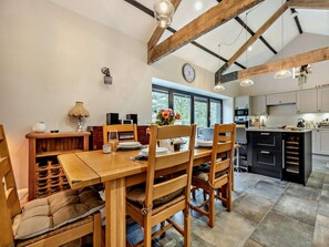 A dining area with wooden furniture, a clock, and a view of the kitchen. - 2 Bed in Cleator (oc-93196) (Ennerdale and Kinniside)