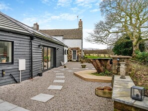 A house with a gravel patio, stone steps, and a garden with a tree and a stone structure. - 2 Bed in Cleator (oc-93196) (Ennerdale and Kinniside)