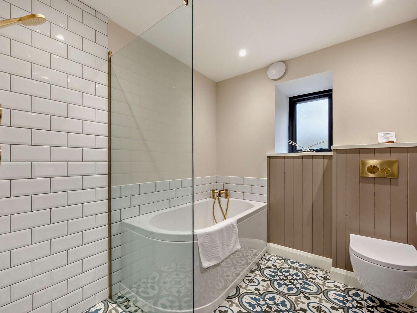 Une salle de bain moderne avec une douche à parois de verre, une baignoire sur pieds et des toilettes.