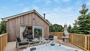A wooden deck with a hot tub, outdoor seating, and a fireplace. - 2 Bed in Paignton (oc-93062) (Marldon)