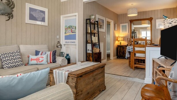 Een gezellige woonkamer met een bank, een houten salontafel en een televisie.