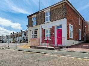 A two-story residential building with a red door, a white front porch, and a brick facade. - 3 Bed in Cowes (oc-92719) (Cowes)