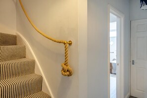 A staircase with striped carpet and a rope tied to the wall. - 3 Bed in Cowes (oc-92719) (Cowes)