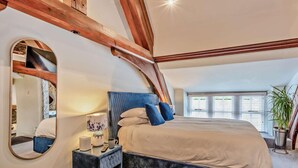 A bedroom with a large bed, a bedside table, a mirror, and a window with blinds. - 2 Bed in Ambleside (oc-93167) (Hawkshead)