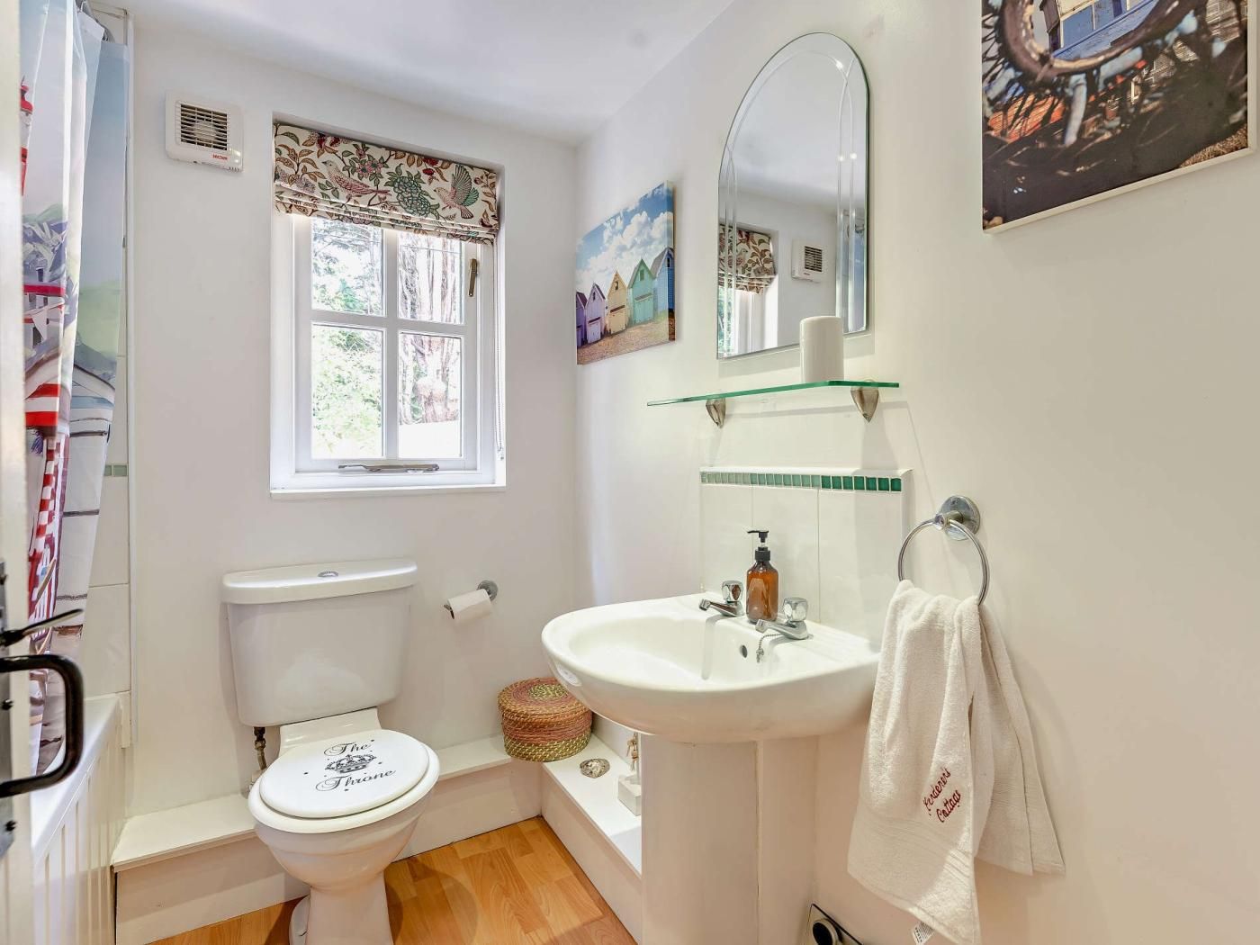 Een kleine badkamer met toilet, wastafel en raam.