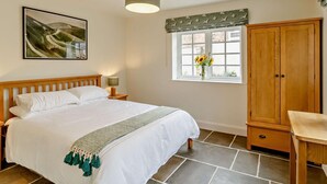 A bedroom with a bed, a nightstand, a lamp, a window with a view, a wardrobe, and a painting on the wall. - 2 Bed in Harrogate (oc-92721) (Bishop Monkton)