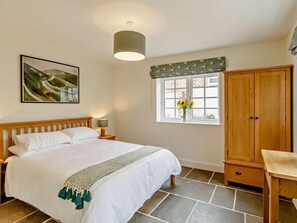 A bedroom with a bed, a nightstand, a lamp, a window with a view, a wardrobe, and a painting on the wall. - 2 Bed in Harrogate (oc-92721) (Bishop Monkton)
