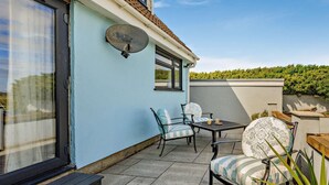 A patio with a table and chairs, a satellite dish, and a view of a hedge. - 3 Bed in Burnham-on-sea (oc-92964) (Brean)