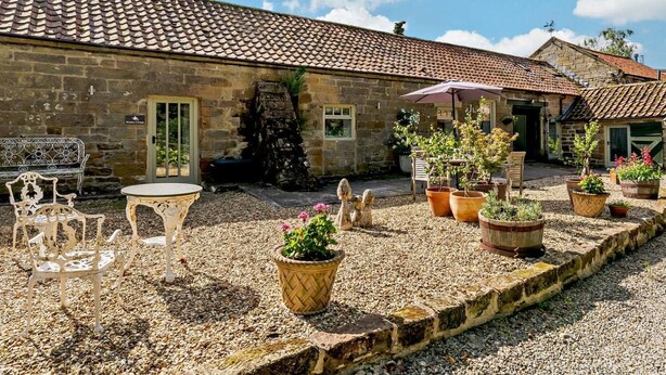 A stone building with a tiled roof, outdoor seating, and potted plants. - 2 Bed in Chop Gate (oc-93098) (Chop Gate)