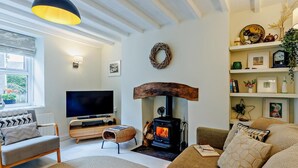 A cozy living room with a fireplace, a television, and a comfortable seating area. - 1 Bed in Machynlleth (oc-92689) (Pennal)