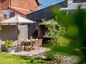 A patio with a table and chairs, a satellite dish, and a garden with various plants. - 2 Bed in Helmsley (oc-92946) (Helmsley)