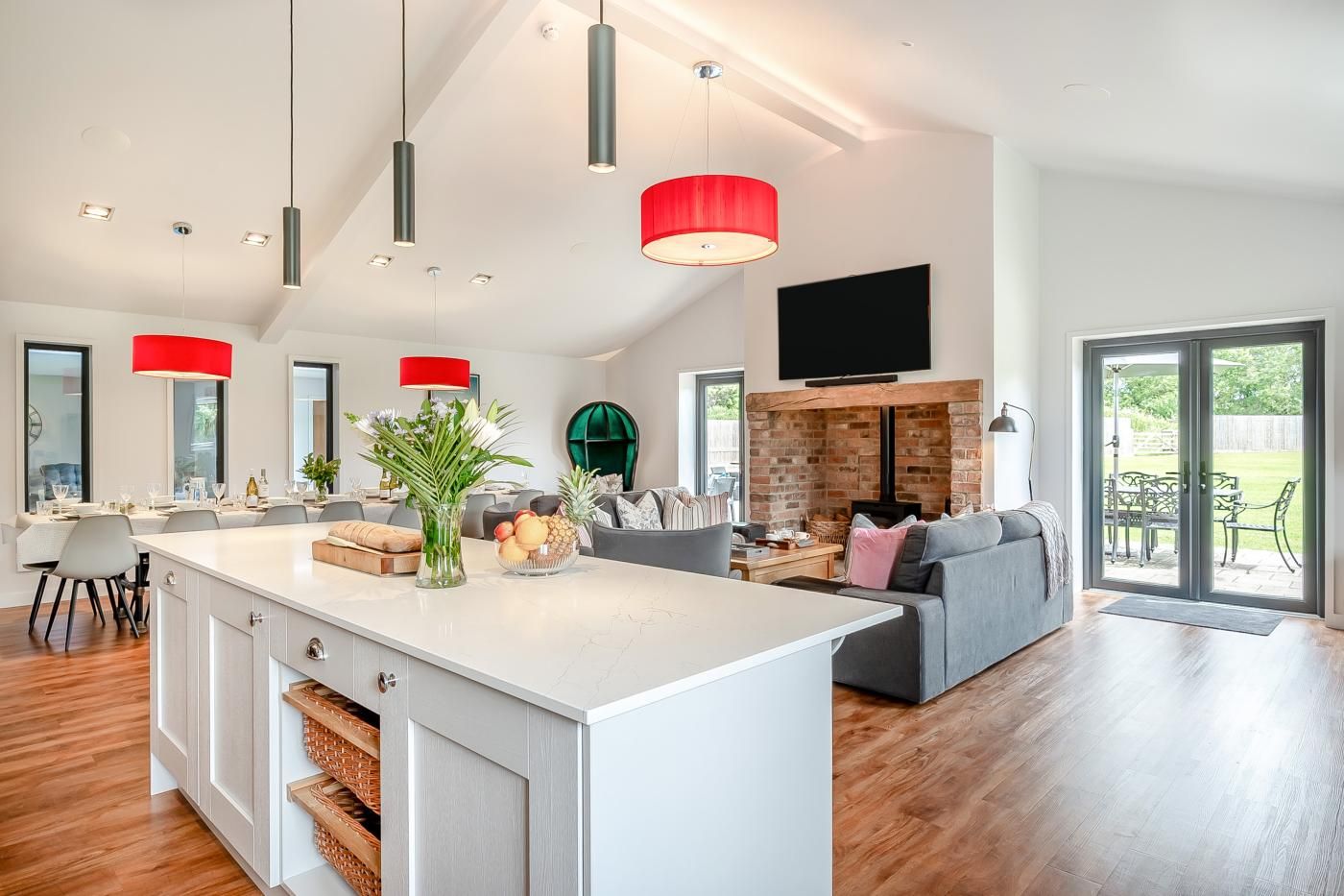 A spacious living area with a large island, a fireplace, and a sliding glass door to the outdoors.