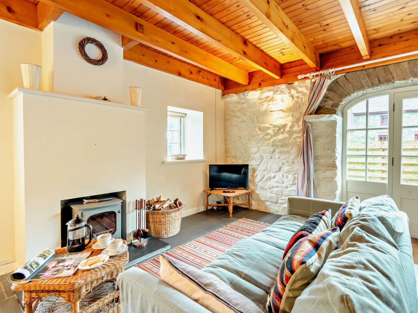 Ein gemütliches Wohnzimmer mit Kamin, Fernseher und bequemer Couch.