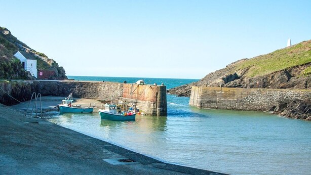 A harbor with boats docked, a stone wall, and a lighthouse in the background. - 3 Bed in Haverfordwest (oc-92675) (Solva)