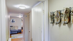 Un couloir avec un radiateur, une porte et un mur orné de décorations en métal de style rustique.