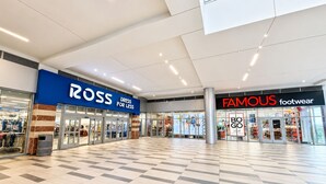A shopping mall interior with stores like Ross and Famous Footwear. - Design District suite with free parking, centrally located. (Miami)