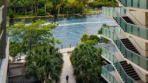 A modern building with multiple balconies overlooking a water body and greenery. - Design District suite with free parking, centrally located. (Miami)