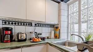 A kitchen with a coffee maker, toaster, and croissant on the counter. - 3 Bed in Machynlleth (oc-93083) (Cwm-Llinau)