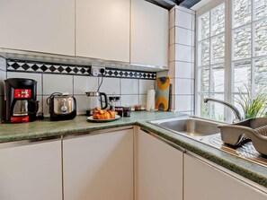 A kitchen with a coffee maker, toaster, and croissant on the counter. - 3 Bed in Machynlleth (oc-93083) (Cwm-Llinau)