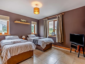 A bedroom with two beds, a TV, and a window with curtains. - 3 Bed in Gairloch (oc-92714) (Badachro)
