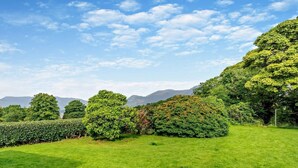 A well-maintained grassy area with a variety of trees and a clear sky. - 3 Bed in Keswick (oc-93202) (Keswick)