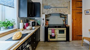 Eine kleine Küche mit Steinrückwand, einer Holztür und einem Essbereich.