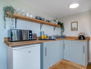 Eine Küche mit einem Toaster, Wasserkocher und einem kleinen Kühlschrank.