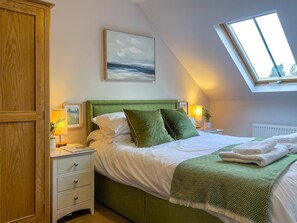 A bedroom with a bed, bedside tables, a nightstand, a window, and a painting on the wall. - 2 Bed in Torquay (oc-82540) (Torquay)