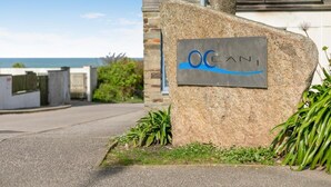 Een stenen bord met 'OCANI' en een blauw golfpatroon, wat een kustplaats aangeeft.