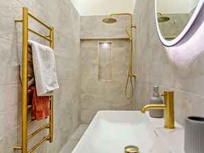 A modern bathroom with a white sink, gold fixtures, and a towel rack with multiple towels. - 1 Bed in Northallerton (oc-93792) (North Cowton)