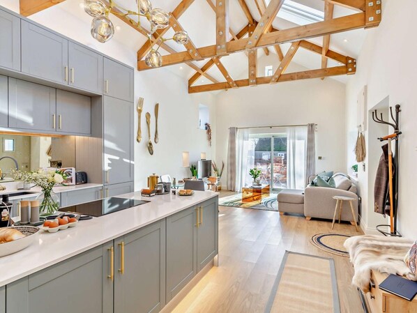 A modern kitchen with grey cabinets, a central island, and a dining area with a sofa and coffee table. - 1 Bed in Northallerton (oc-93792) (North Cowton)