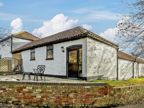 A white building with a tiled roof, a brick wall in front, and a door with a window. - 1 Bed in Doncaster (oc-93768) (Mattersey)