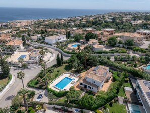 A residential area with multiple houses, each featuring a swimming pool, surrounded by greenery and a curved road. - Casa Vista Linda | Private Sea View Villa & Saltwater Pool (LUZ-LGS)