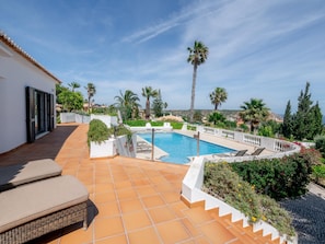 A rooftop pool with a view of the sea, surrounded by palm trees and a white building. - Casa Vista Linda | Private Sea View Villa & Saltwater Pool (LUZ-LGS)