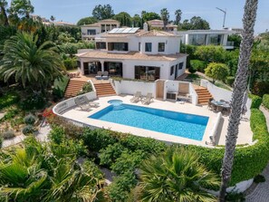 A modern two-story house with a swimming pool, surrounded by lush greenery and palm trees. - Casa Vista Linda | Private Sea View Villa & Saltwater Pool (LUZ-LGS)