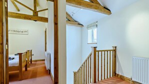 A room with a wooden staircase, a bed, a radiator, and a window. - 2 Bed in Doncaster (oc-93770) (Mattersey)