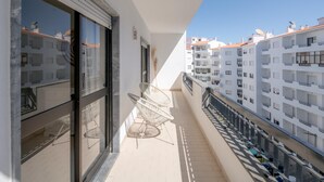 A balcony with a chair, a window, and a view of adjacent buildings. - Lagos Urban Hideout: Discover your own little city retreat in the heart of Lagos (Lagos)