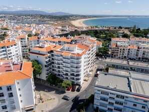 Eine Küstenstadt mit moderner Architektur, einem Strand und blauem Himmel.