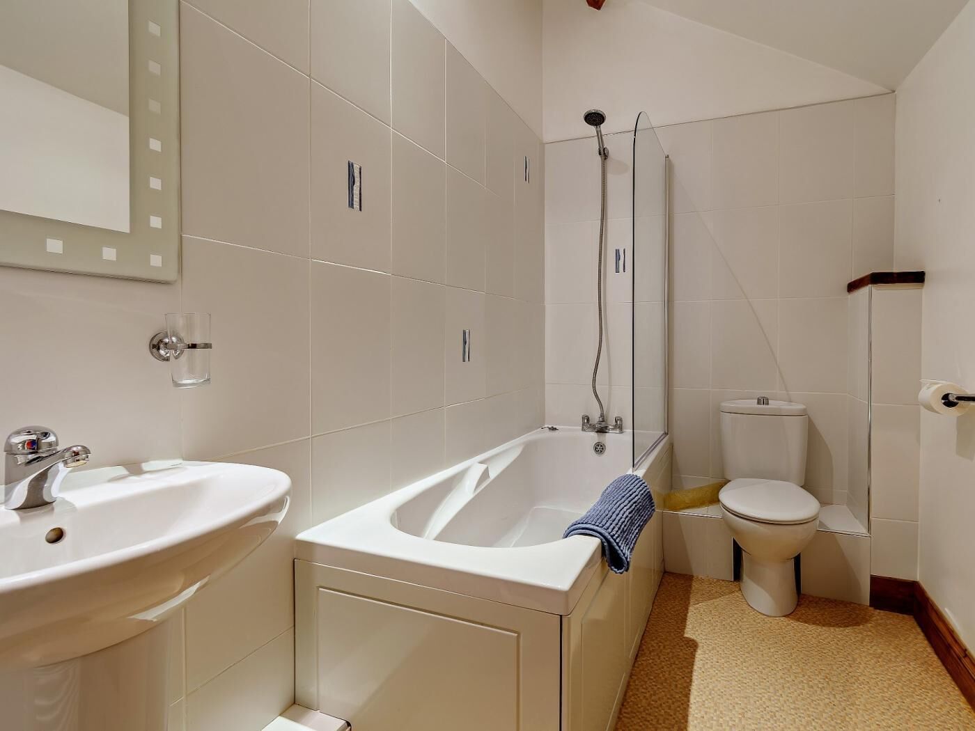 A bathroom with a bathtub, sink, toilet, and a shower area.