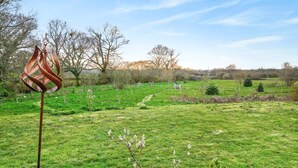 A grassy field with a metal sculpture, trees, and a clear sky. - 1 Bed in Sturminster Newton (oc-93841) (Hazelbury Bryan)